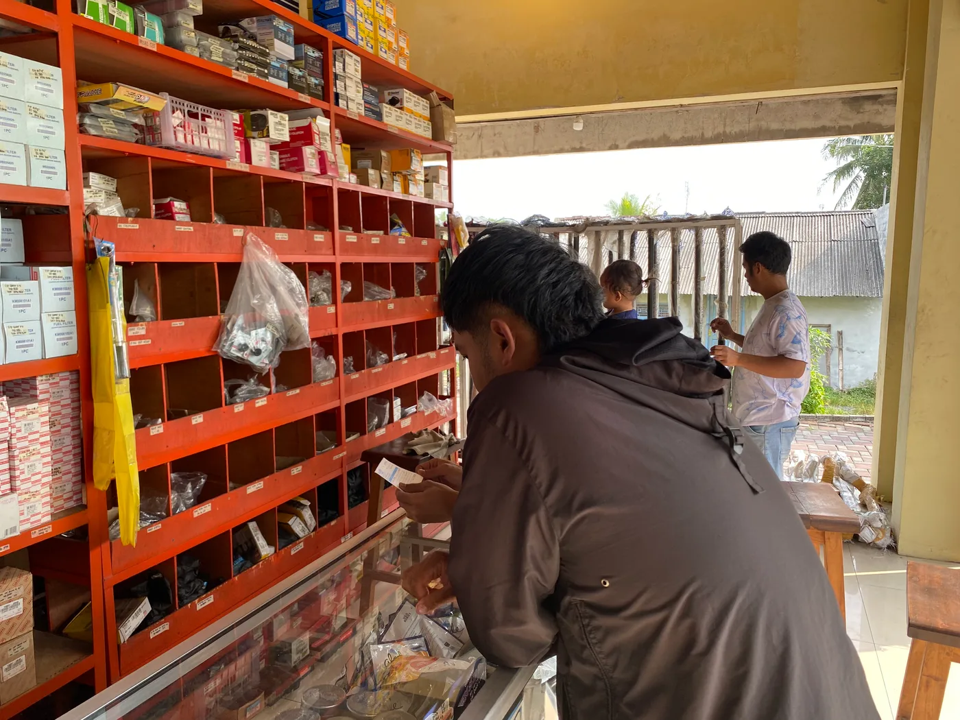 Mahasiswa mengamati rak-rak wadah makanan dan meja persiapan di sebuah dapur
